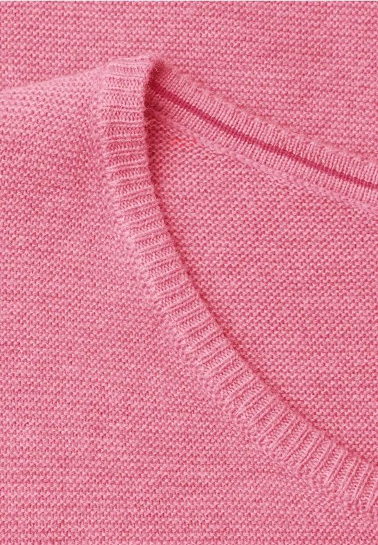 Nahaufnahme eines rosa Strickpullovers mit V-Ausschnitt