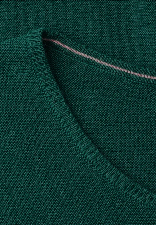 Nahaufnahme eines grünen, fein gestrickten V-Ausschnitt-Pullovers