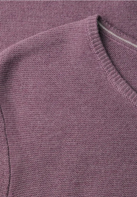 Gros plan d’un haut en maille violette avec encolure ronde.