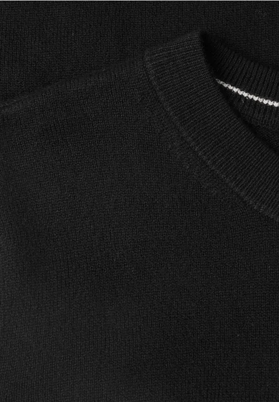 Gros plan d'un t-shirt noir à col rond en coton.