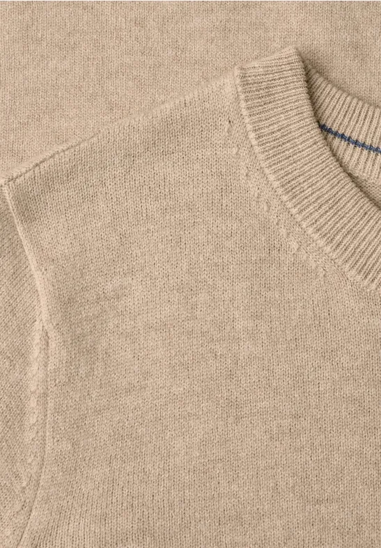Nahaufnahme eines hellbeigen Strickpullovers mit Rundhalsausschnitt.