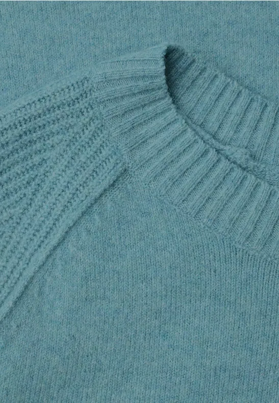 Detailaufnahme eines türkisfarbenen Strickpullovers mit Rippenmuster an Kragen und Schultern.
