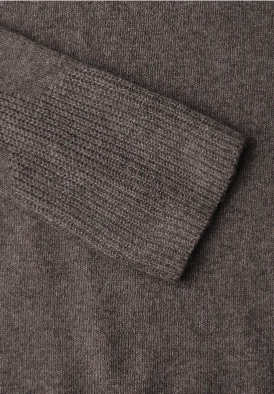Maille brune douce avec bord-côte fin à la manche, surface texturée chaleureuse.