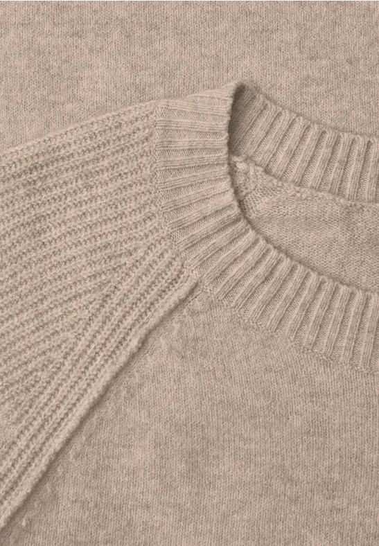 Nahaufnahme eines beigen Strickpullovers mit Rundhalsausschnitt