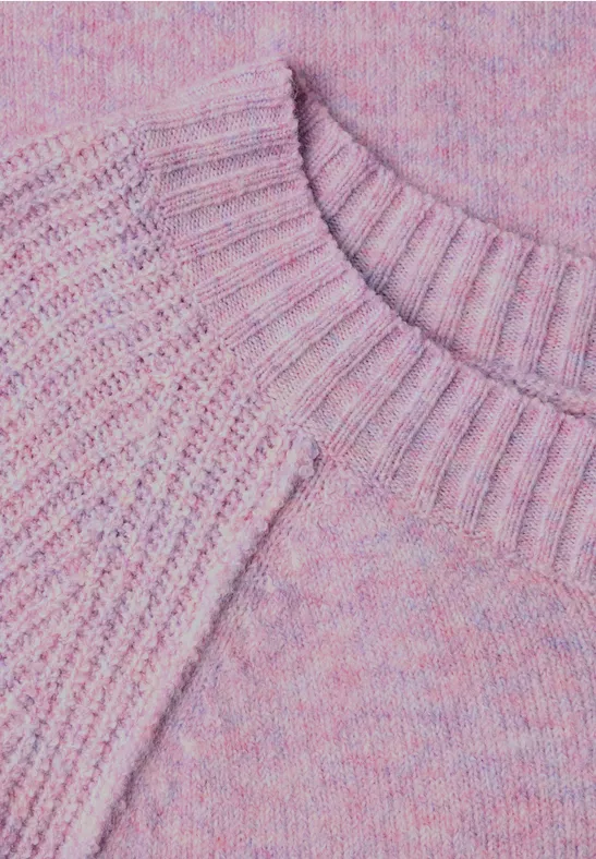 Close-up van een roze-lila gebreide trui met ronde hals.
