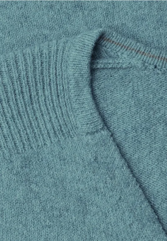 Close-up van een turquoise trui van fijn breiwerk met omgeslagen boord