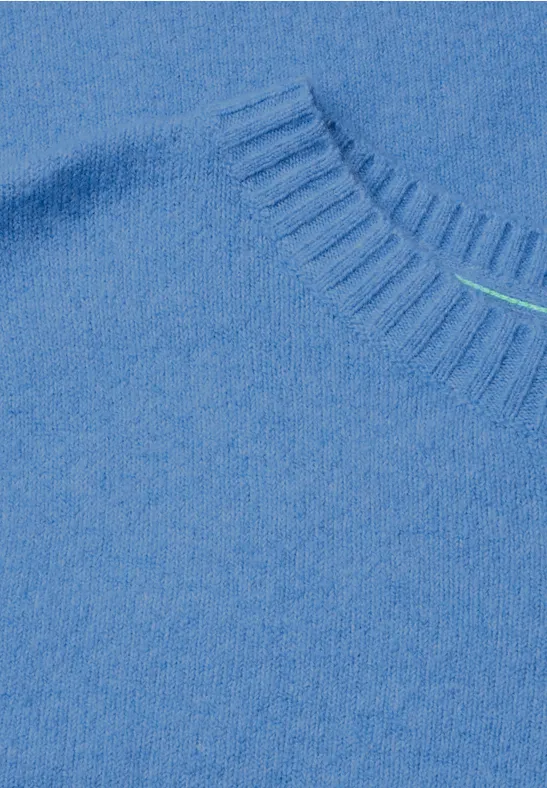 Close-up van een lichtblauwe trui met zachte, pluizige stof bij de hals.