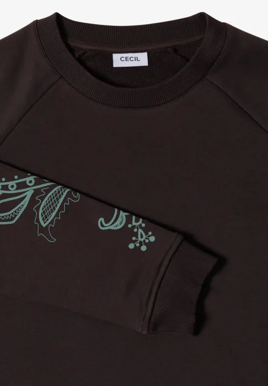 Braunes Sweatshirt mit grünem Blatt-Muster am Ärmel und kleinem Markenlabel im Nacken.