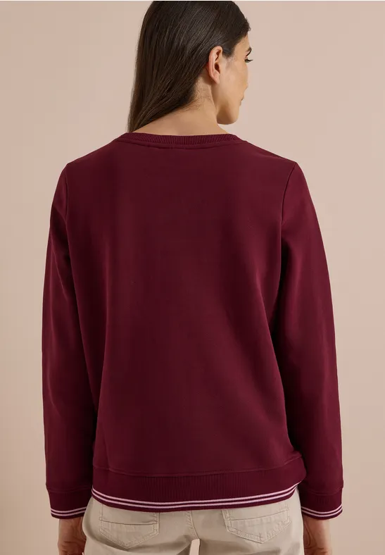 Rückenansicht eines burgunderroten Sweatshirts mit Rundhalsausschnitt und gestreiften Bündchen.