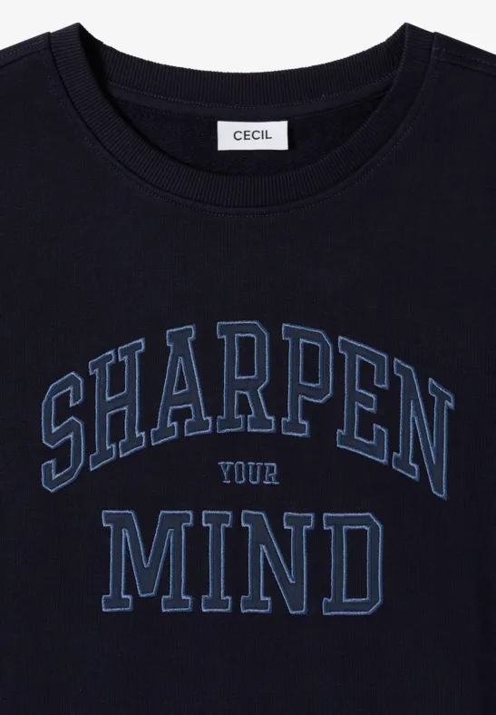 Ein schwarzes T-Shirt mit dem Aufdruck 'SHARPEN YOUR MIND' und einem CECIL-Label im Nackenbereich.