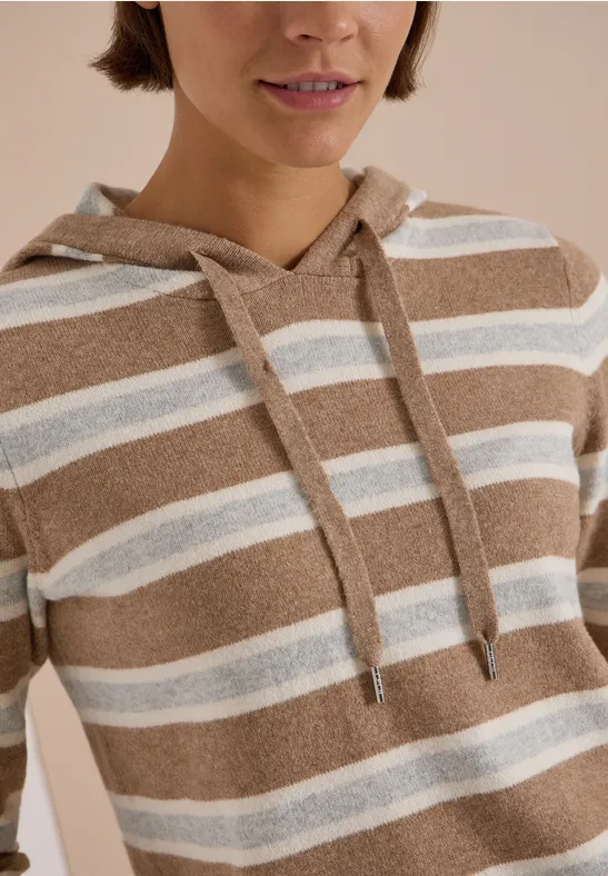 Gros plan sur un sweat à capuche marron et blanc à rayures avec cordon.