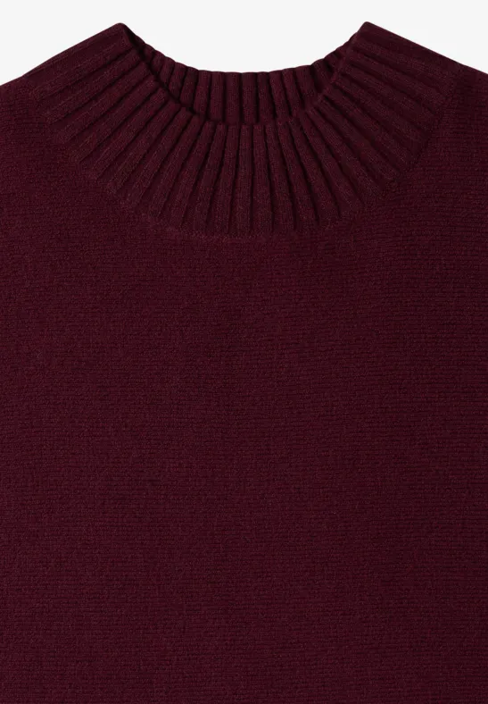 Ein schlichtes, dunkelrotes Strickshirt mit geripptem Rundhalsausschnitt, flach liegend fotografiert.