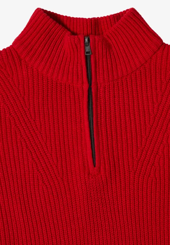 Pull rouge épais en maille grosse, col montant et demi-fermeture éclair sur le devant.