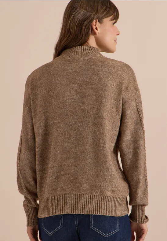 Femme vue de dos portant un pull marron à col montant et manches longues.
