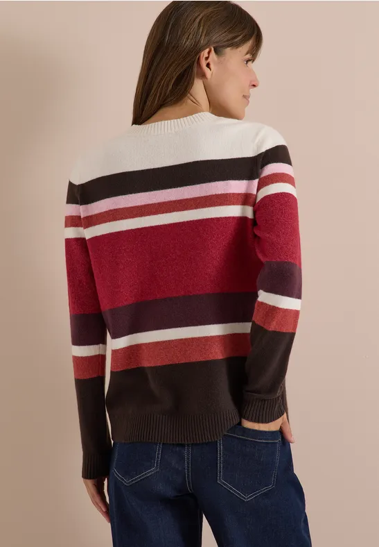 Femme vue de dos portant un pull rayé rouge, blanc et marron.