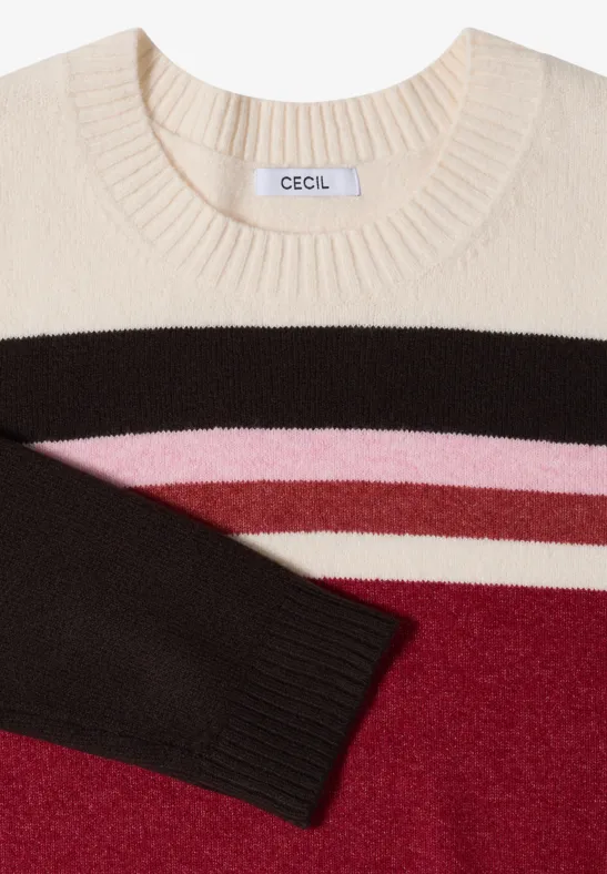 Pull en maille crème à rayures horizontales brun, rose et rouge, avec une manche visible
