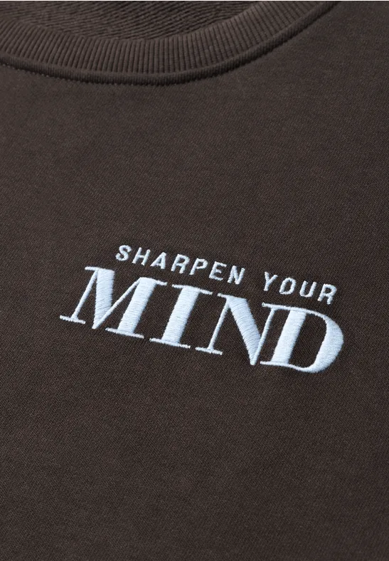 Dunkles T-Shirt mit weißem Aufdruck ‚SHARPEN YOUR MIND‘.