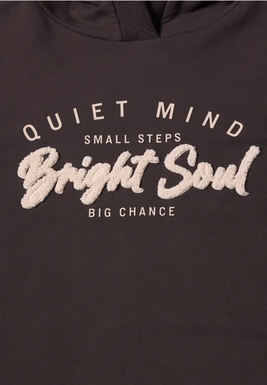 Donker shirt met witte tekst: 'Quiet Mind, Small Steps, Bright Soul, Big Chance'.