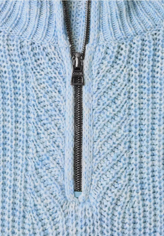 Hellblauer Strickpullover mit Reißverschluss und Rippstrickmuster.