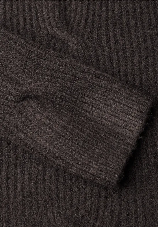Brauner Strickpullover-Ärmel mit feiner Rippenstruktur.