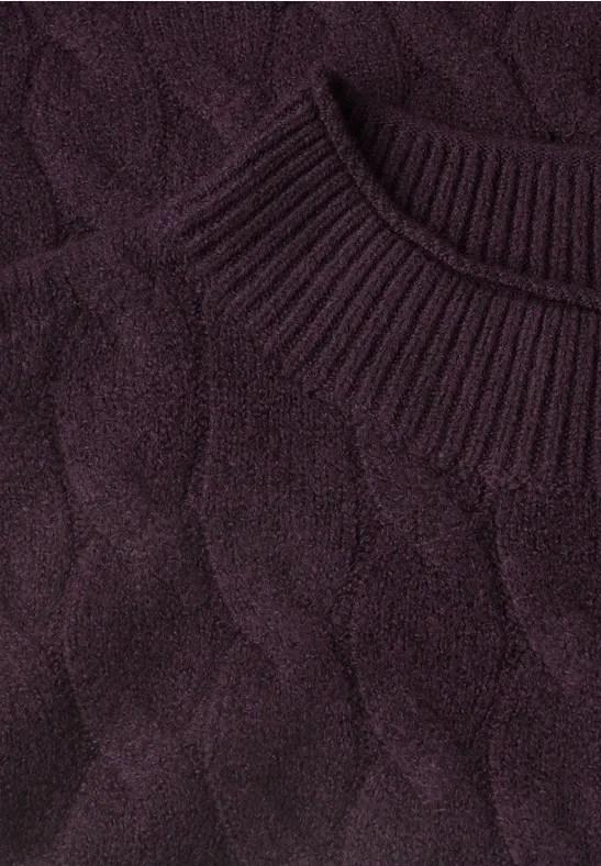 Gros plan sur un pull en maille torsadée violet foncé à col rond côtelé.