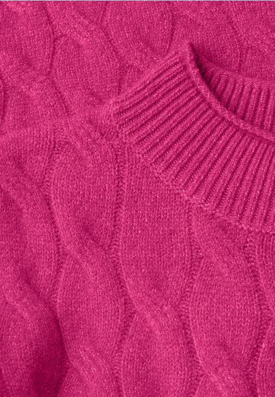 Close-up van een roze gebreide trui met vlechtpatroon