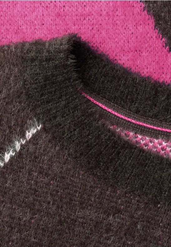 Nahaufnahme eines flauschigen Strickpullovers in Schwarz und Pink
