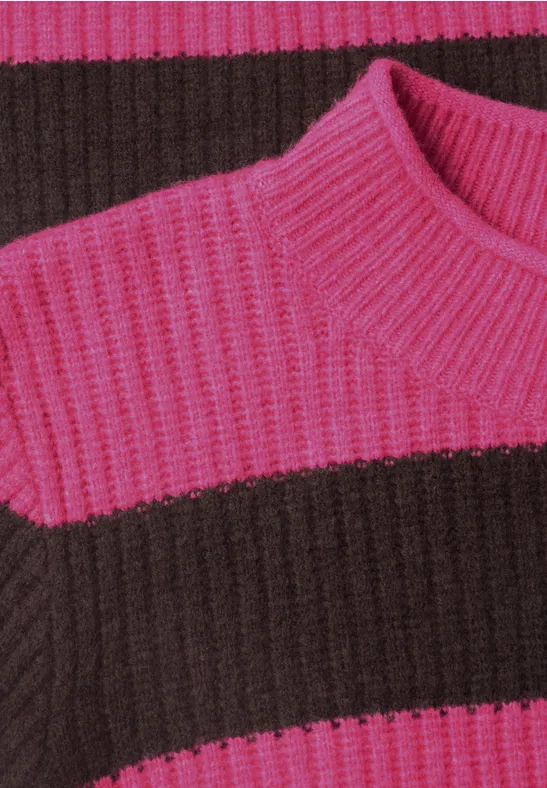 Gros plan d'un pull en maille côtelée à larges rayures roses et marron.