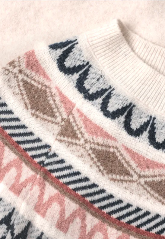 Biały sweter z dzianiny w różowe i niebieskie wzory norweskie.