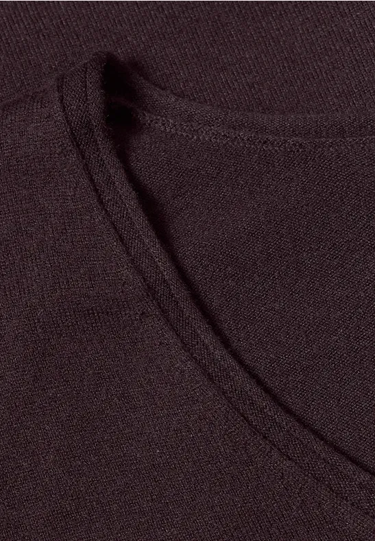 Tissu fin noir avec couture apparente formant un col rond.