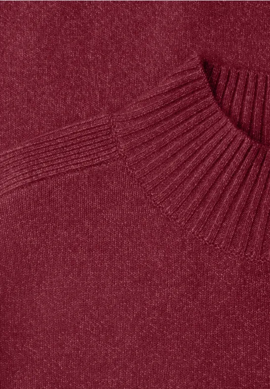 Gros plan d'un pull tricoté bordeaux avec col rond côtelé.