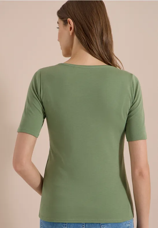 Achteraanzicht van een vrouw met een eenvoudig groen T-shirt met halflange mouwen.