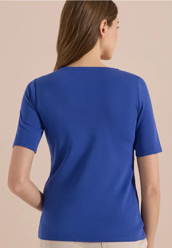 Achteraanzicht van een vrouw in een blauw T-shirt.