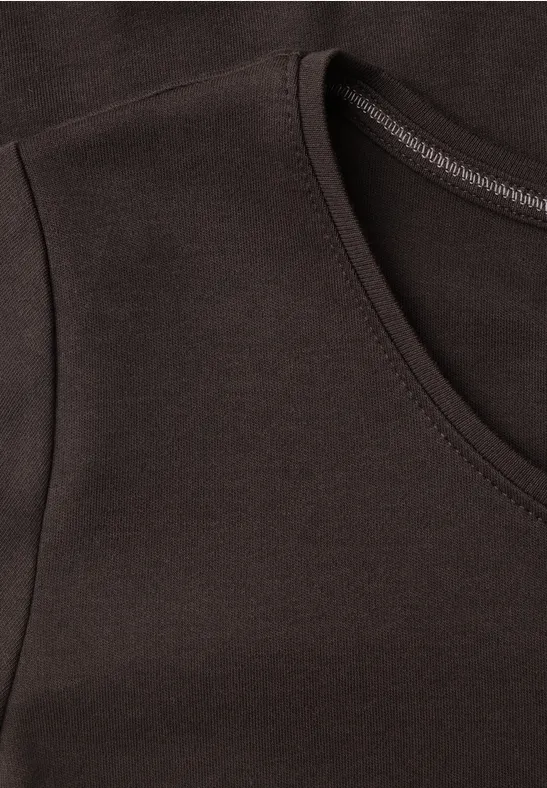 Nahaufnahme eines dunklen T-Shirts mit Rundhalsausschnitt und sauberer Naht.