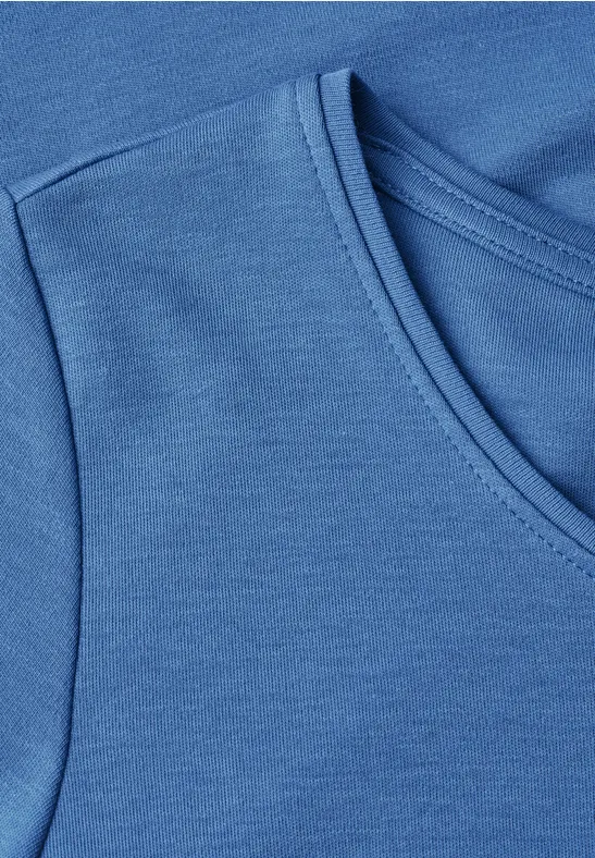 Detailaufnahme eines blauen T-Shirts mit Rundhalsausschnitt und glattem Baumwollstoff.