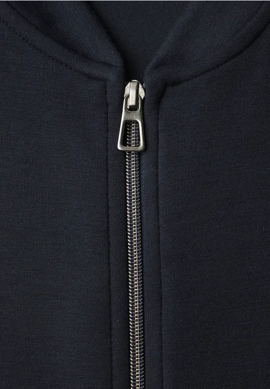 Nahaufnahme eines Metallreißverschlusses an einer dunkelblauen Jacke.