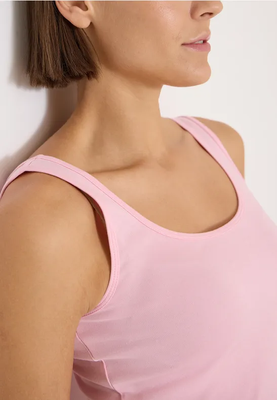 Femme en débardeur rose regardant sur le côté