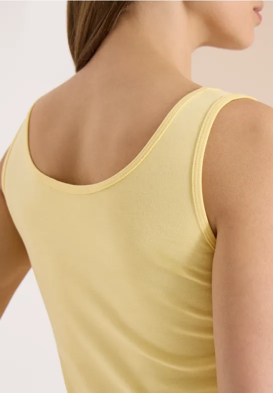 Achteraanzicht van een vrouw in een geel tanktopje