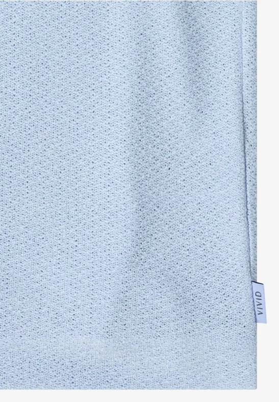 Lichtblauwe, ademende sportstof met kleine gaatjes en een zijlabel