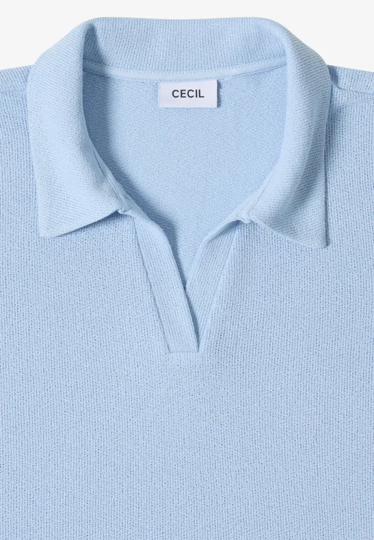 Lichtblauw polohemd op witte achtergrond, opgevouwen.