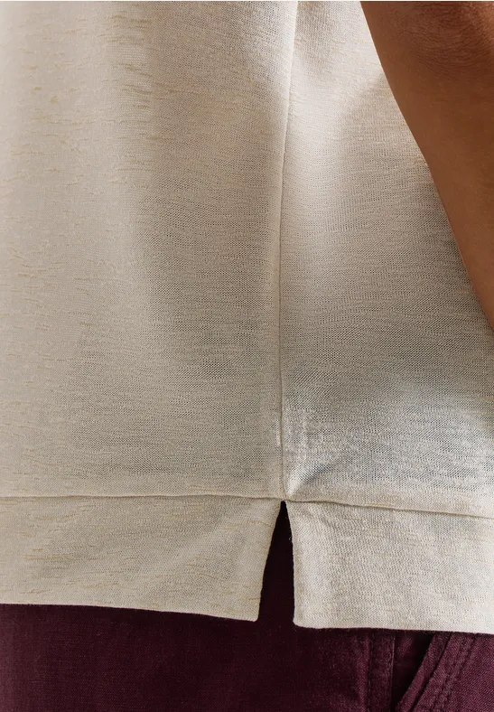 Beige satijnen top met een zijsplit, gedragen op een donkerrode broek.