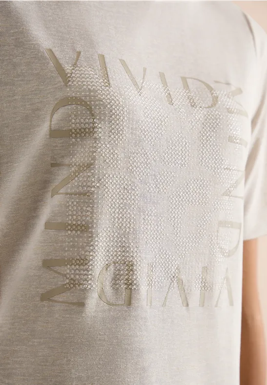 Beige T-shirt met glanzende gouden opdruk, met in grote letters ‘VIVID MIND’.