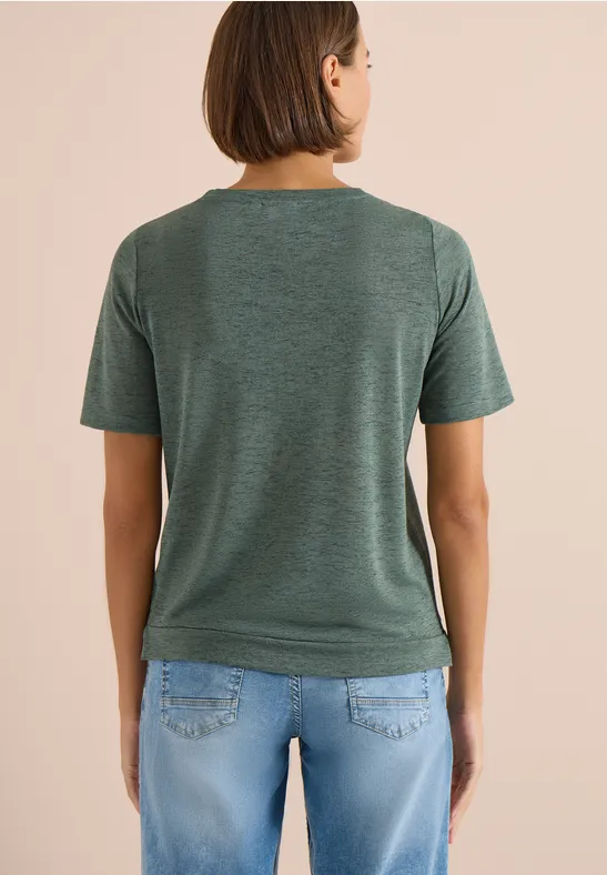 Vrouw van achteren, draagt een groen t-shirt en een blauwe jeans.