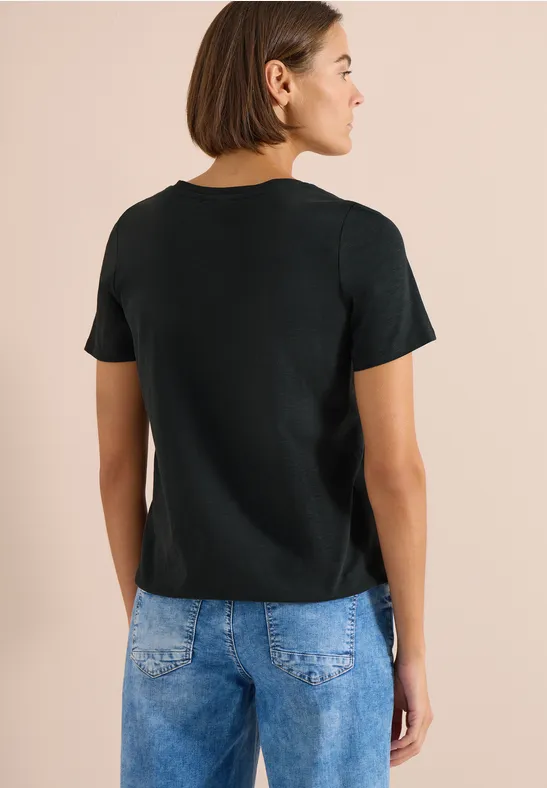 Achteraanzicht van een persoon met zwart shirt en blauwe spijkerbroek