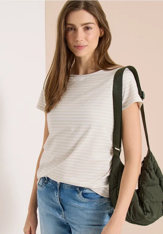 Frau in gestreiftem T-Shirt und Jeans, trägt grüne Schultertasche