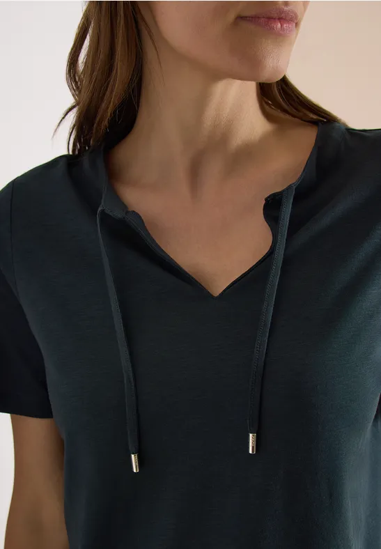 Femme en T-shirt vert foncé à encolure en V avec cordons