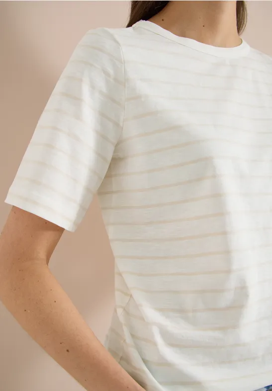 Een persoon draagt een wit t-shirt met subtiele beige strepen.