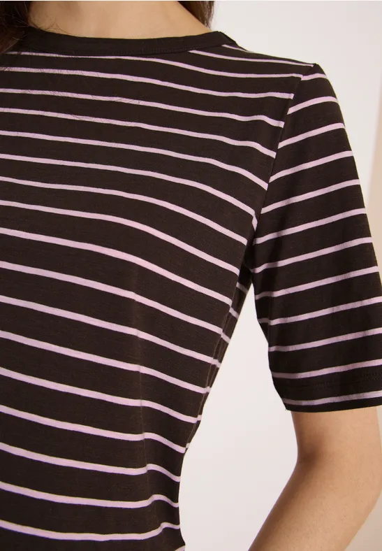 Close-up van een persoon in een zwart T-shirt met fijne roze horizontale strepen.