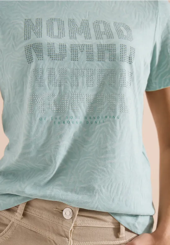 Heller T-Shirt mit Zebramuster und Schriftzug "NOMAD NUMBER", kombiniert mit hellen Hosen
