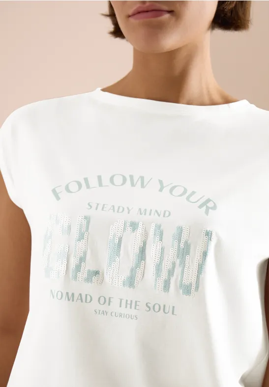 Vrouw draagt wit T-shirt met pastelopdruk en grafisch motief op de borst.